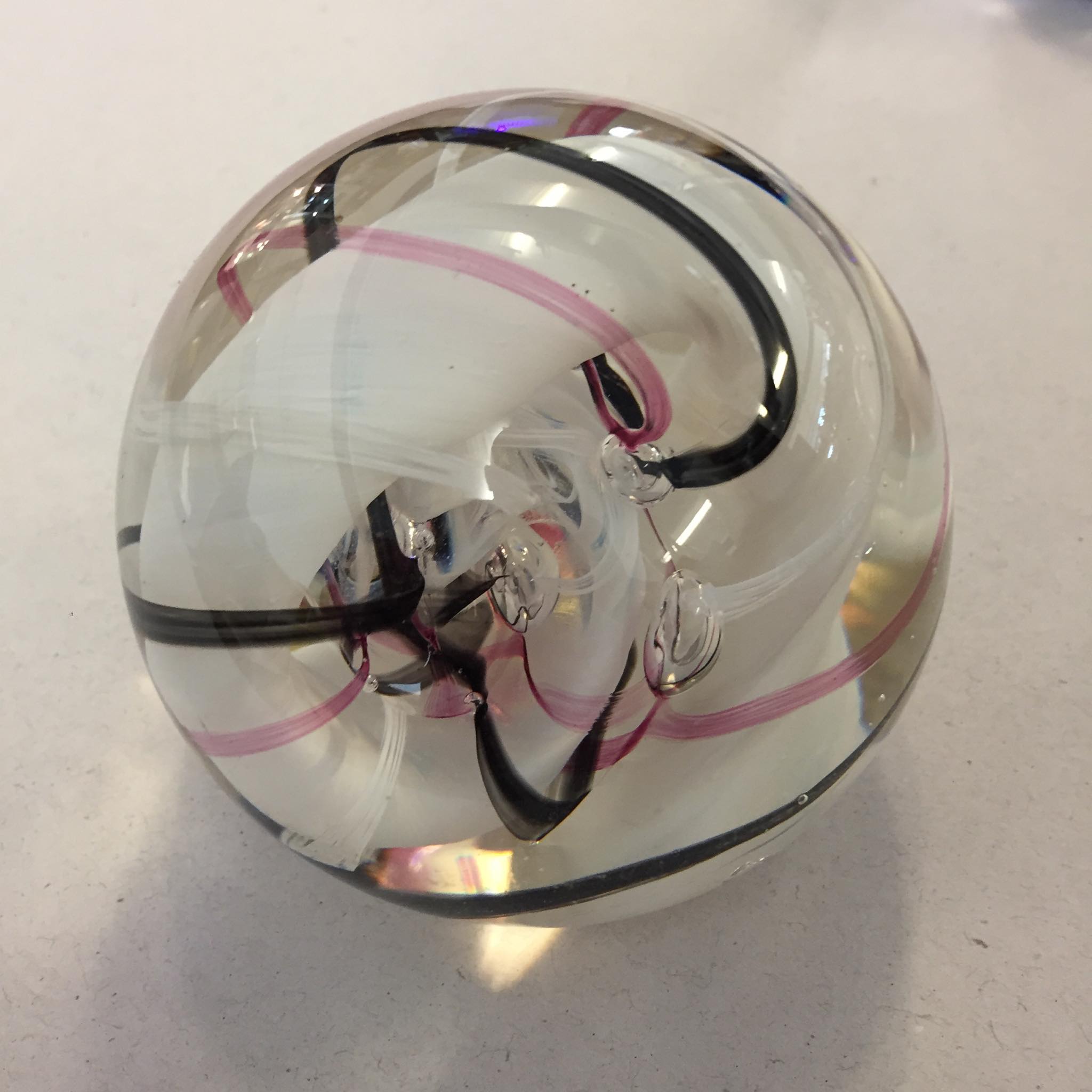 vintage Caithness Ribbons art glass paperweight from Scotland, featuring pink, white, and black swirls encased in clear glass
